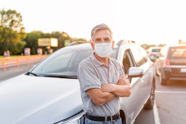 Homem de tiro médio posando perto do carro