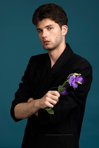 Foto grátis homem de tiro médio segurando flor roxa