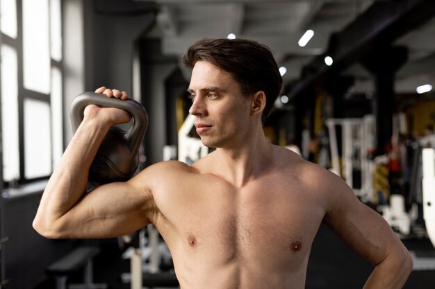 Homem de tiro médio segurando kettlebell