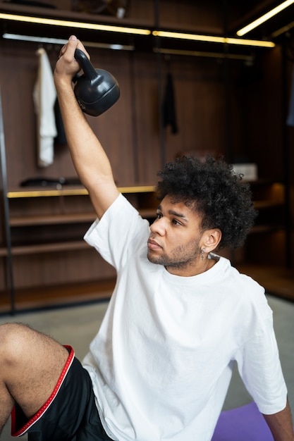 Homem de tiro médio segurando kettlebell