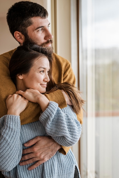 Foto grátis homem de tiro médio segurando uma mulher sorridente