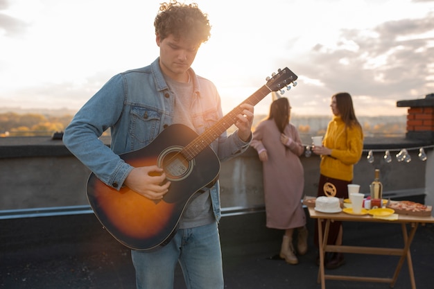 Foto grátis homem de tiro médio tocando violão