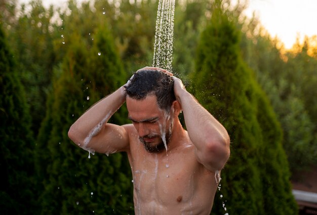 Homem de tiro médio tomando banho