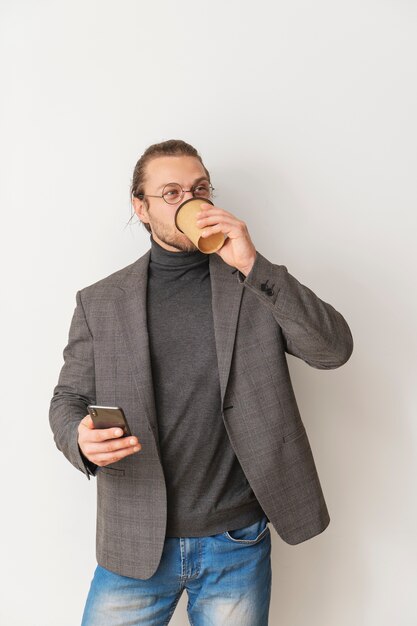 Homem de tiro médio tomando café