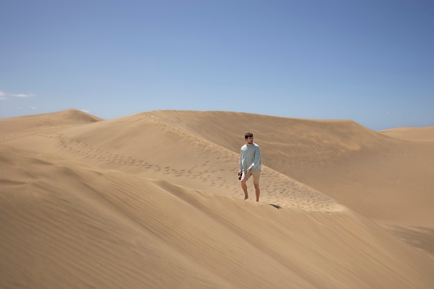 Homem de tiro no escuro com câmera no deserto