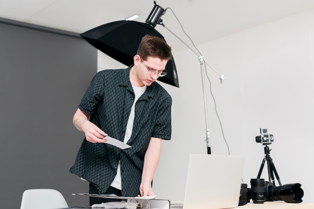 Foto grátis homem de trabalho fotógrafo em pé em seu estúdio