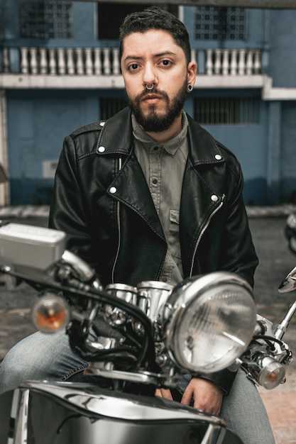 Homem de vista frontal com jaqueta de couro na motocicleta