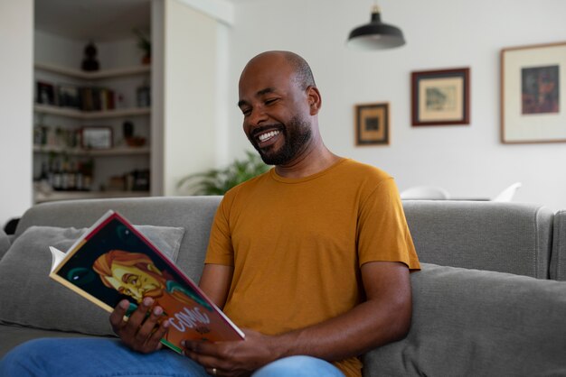 Homem de vista frontal lendo quadrinhos em casa