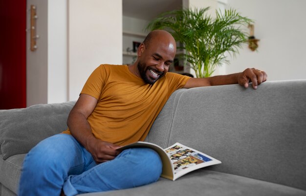 Homem de vista frontal lendo quadrinhos em casa