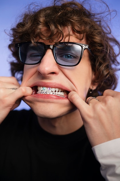 Homem de vista frontal posando com joias dentárias