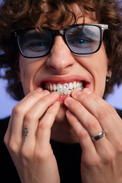 Homem de vista frontal posando com joias dentárias