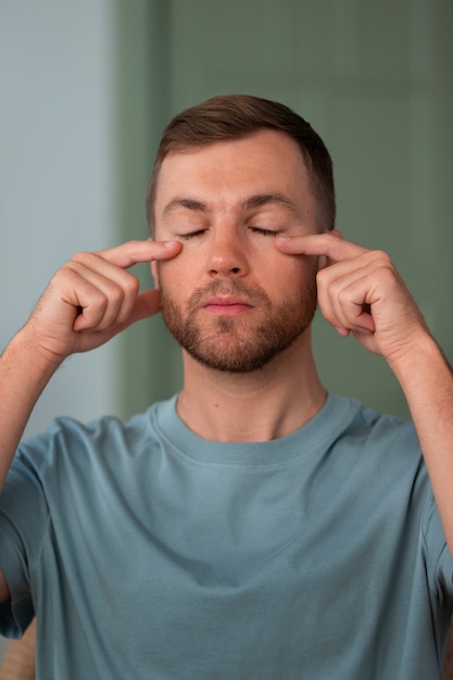 Homem de vista frontal praticando ioga facial