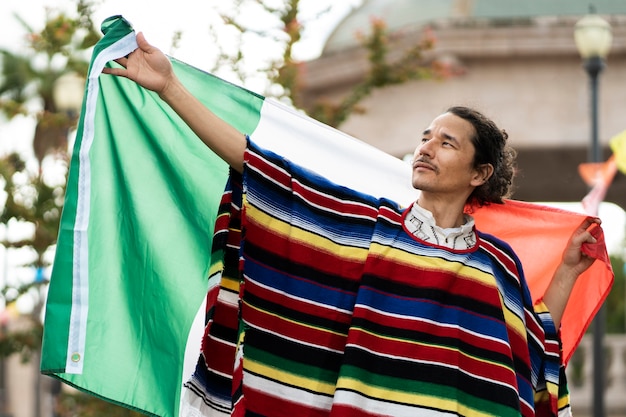 Homem de vista frontal segurando a bandeira mexicana