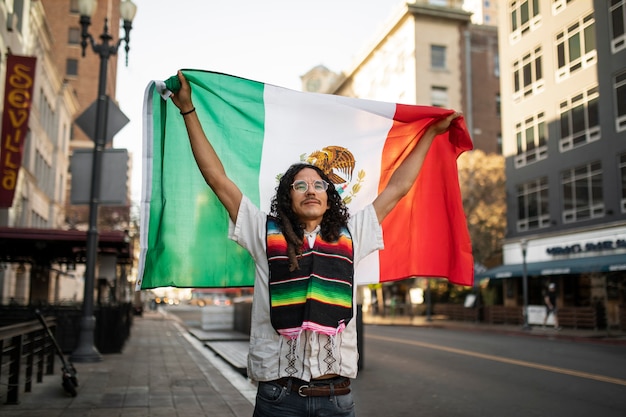 Homem de vista frontal segurando a bandeira mexicana