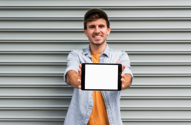 Foto grátis homem de vista frontal segurando o modelo de tablet