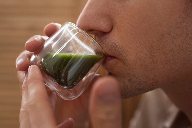 Foto grátis homem de vista lateral bebendo chá matcha