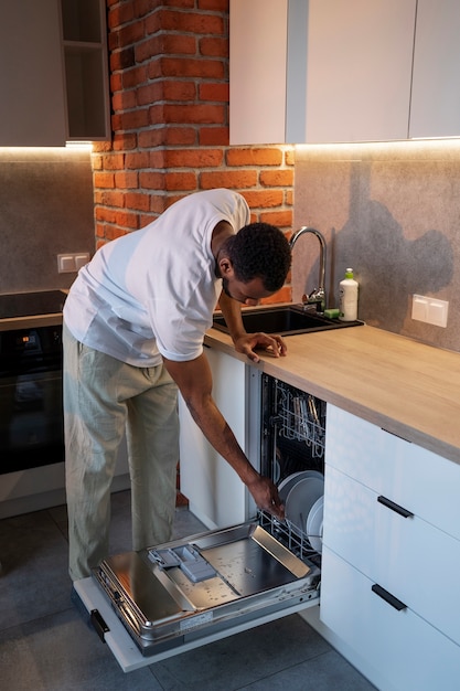 Homem de vista lateral carregando a máquina de lavar louça