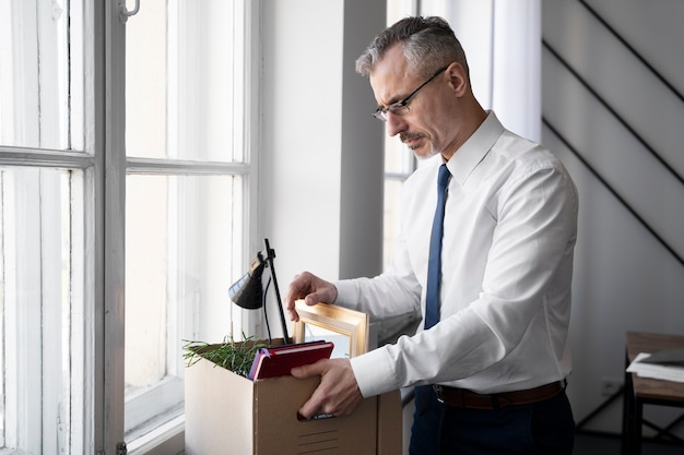 Homem de vista lateral carregando caixa de papelão