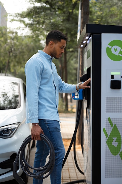 Homem de vista lateral carregando carro elétrico