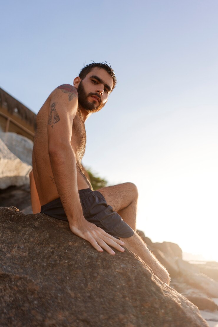 Foto grátis homem de vista lateral com peito peludo à beira-mar