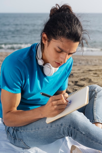 Homem de vista lateral escrevendo no caderno