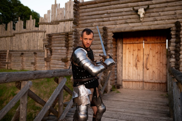 Homem de vista lateral posando como um soldado medieval