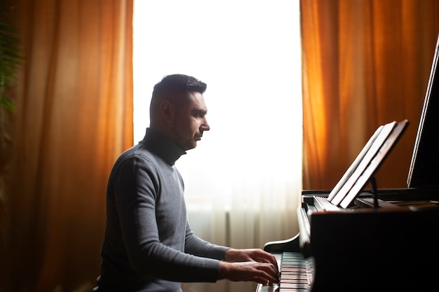 Homem de vista lateral tocando piano