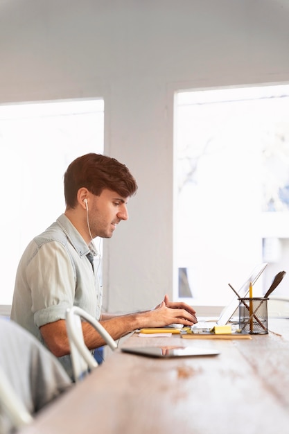 Foto grátis homem de vista lateral trabalhando em um projeto em casa