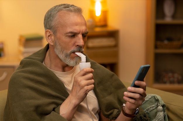 Homem de vista lateral usando nebulizador