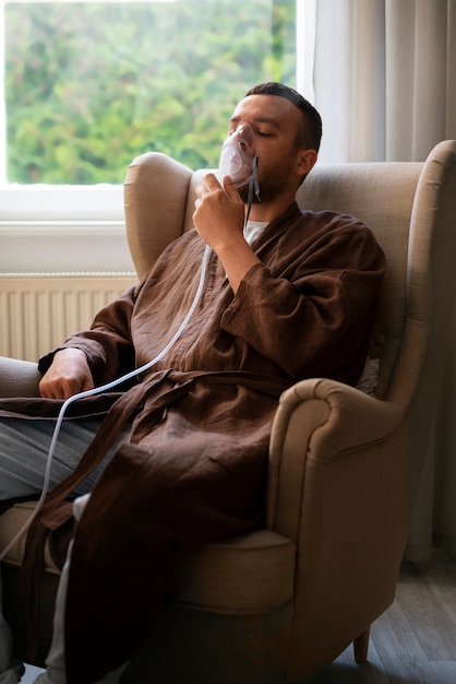 Homem de vista lateral usando um nebulizador