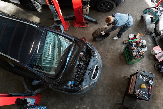 Homem de vista superior consertando carro