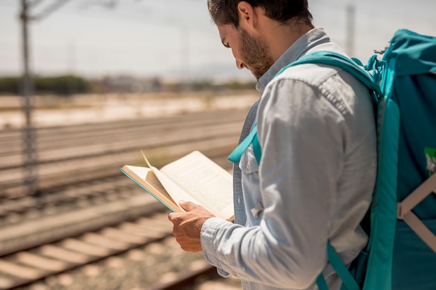 Homem de vista traseira, lendo um livro