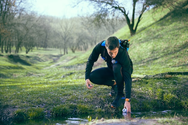 Homem depois de correr em um parque ou floresta contra árvores