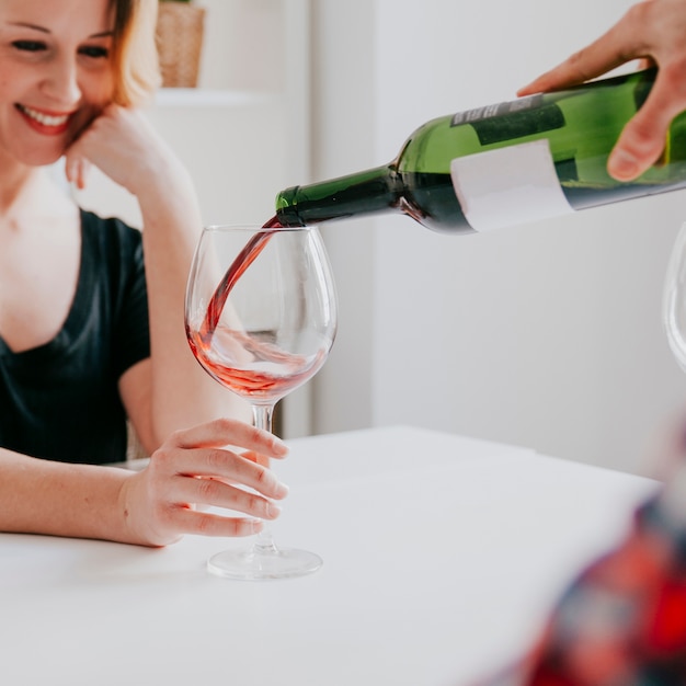 Homem derramando vinho para namorada