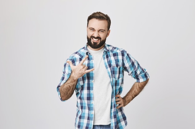 Homem descuidado e feliz de meia-idade mostrando cartaz de rock-n-roll