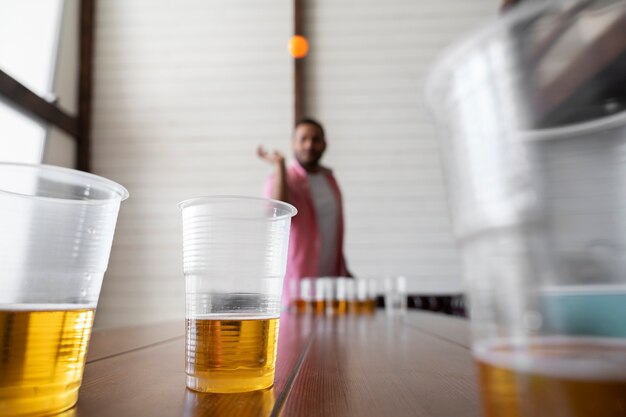 Homem desfocado jogando cerveja pong