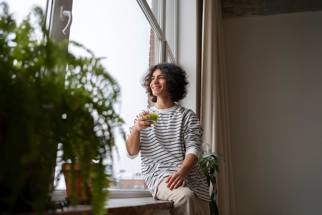 Foto grátis homem desfrutando de uma xícara de chá matcha em casa