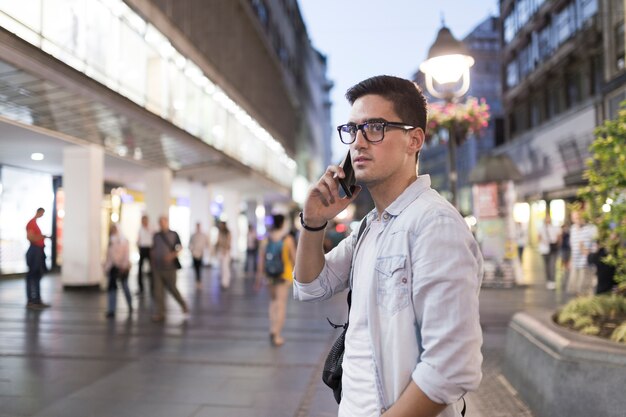 Homem, desgastar, óculos, falando telefone móvel