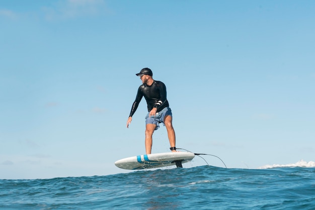 Homem desportivo a surfar no Havai