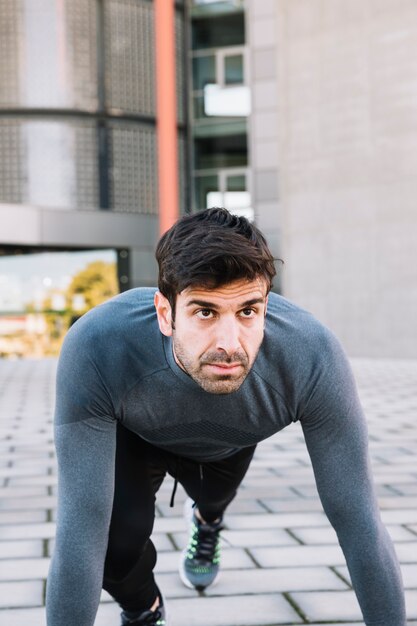 Foto grátis homem desportivo fazendo exercício de prancha na rua