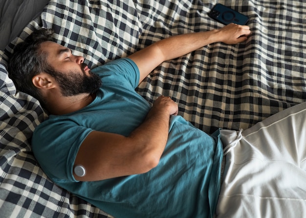 Homem diabético usando sensor de adesivo de glicose