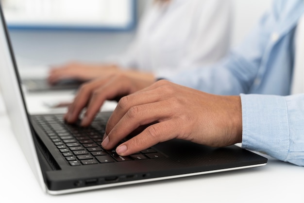 Homem digitando em um teclado de laptop