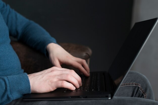 Homem digitando no teclado do seu laptop