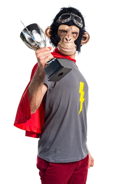 Homem do macaco do super-herói segurando um troféu