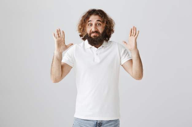 Homem do oriente médio impressionado com barba, mostrando um grande objeto com as mãos estendidas
