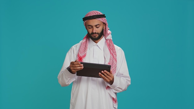 Foto grátis homem do oriente médio verificando tablet