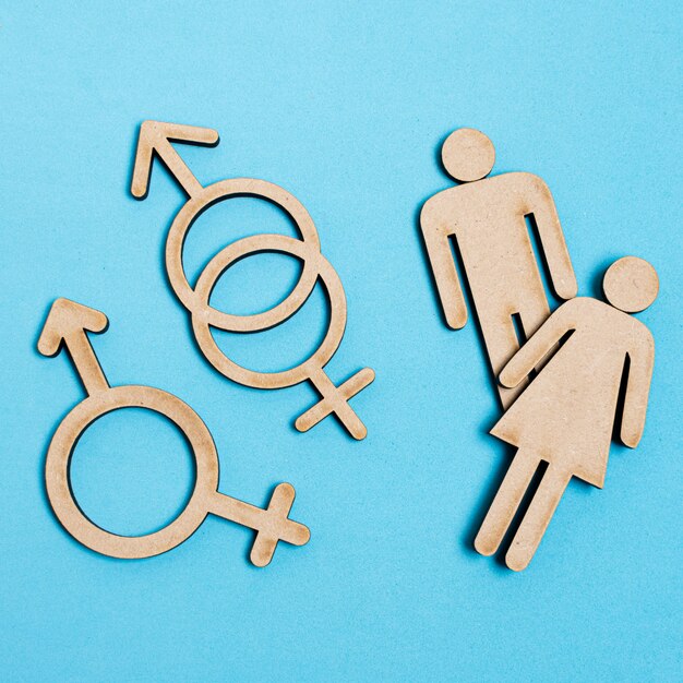 Homem e mulher ao lado de sinais de gênero