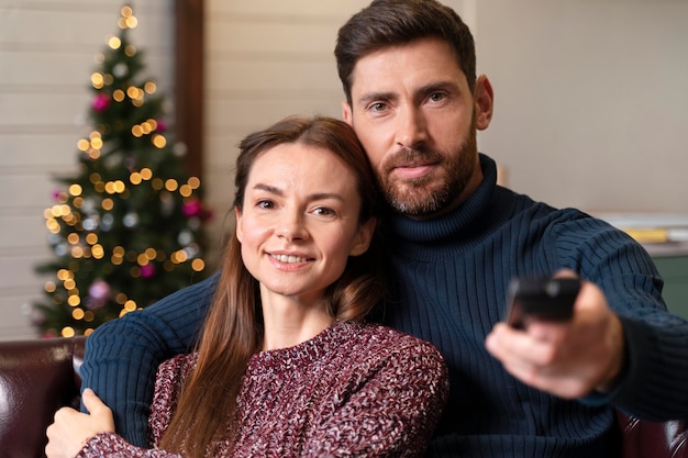 Homem e mulher assistindo tv no natal