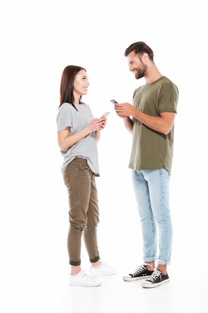 Foto grátis homem e mulher com smartphones olhando uns aos outros