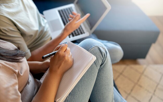 Homem e mulher fazendo lista de compras com laptop